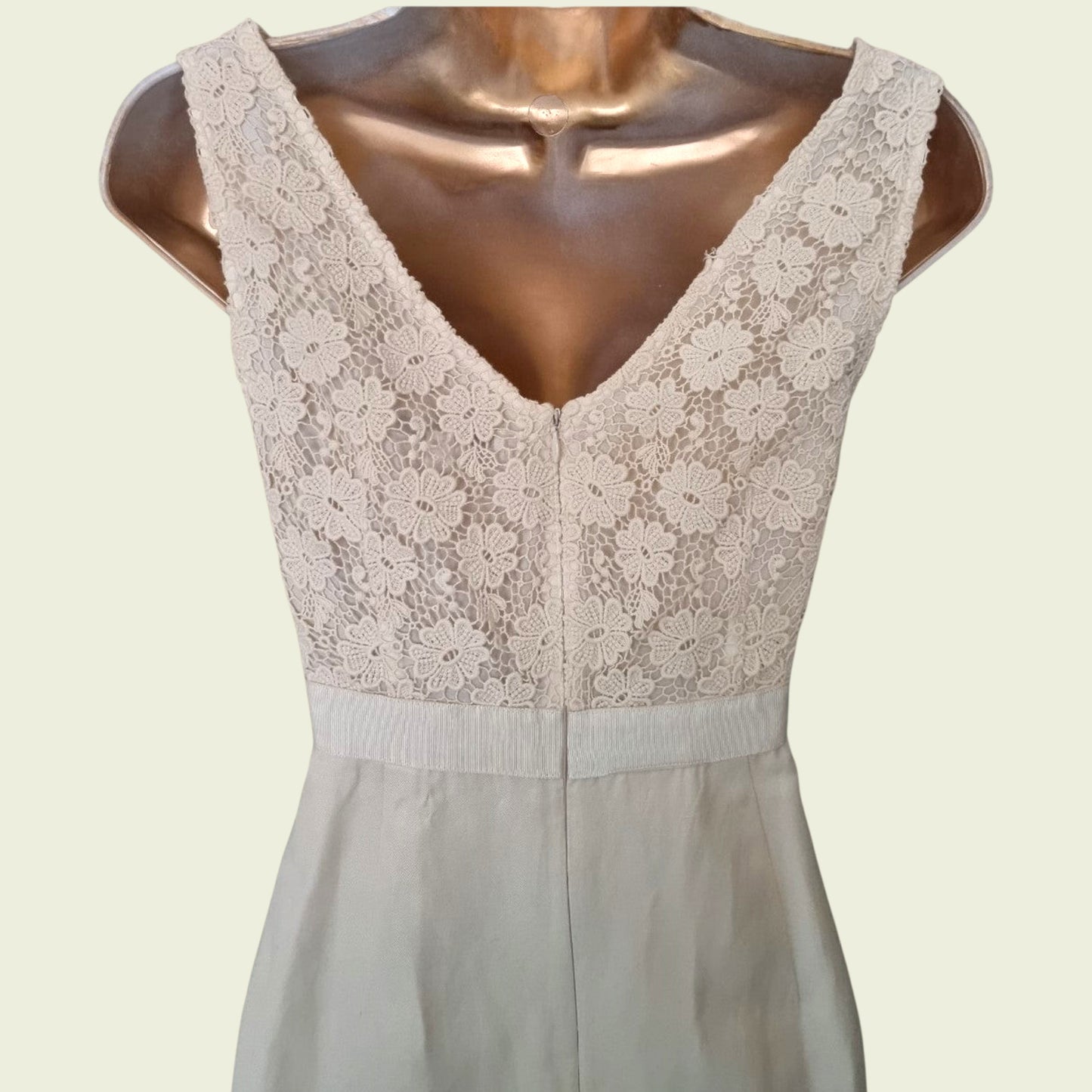 Close up of embroidery on a cream dress on beige background