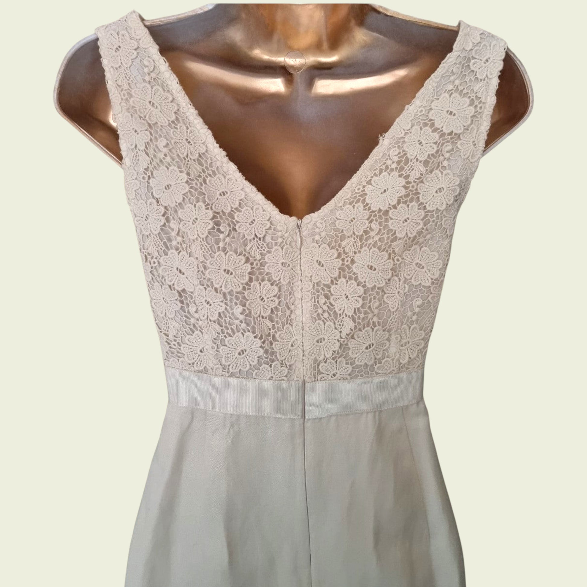 Close up of embroidery on a cream dress on beige background