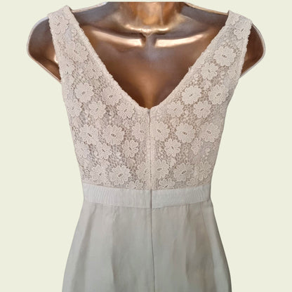 Close up of embroidery on a cream dress on beige background