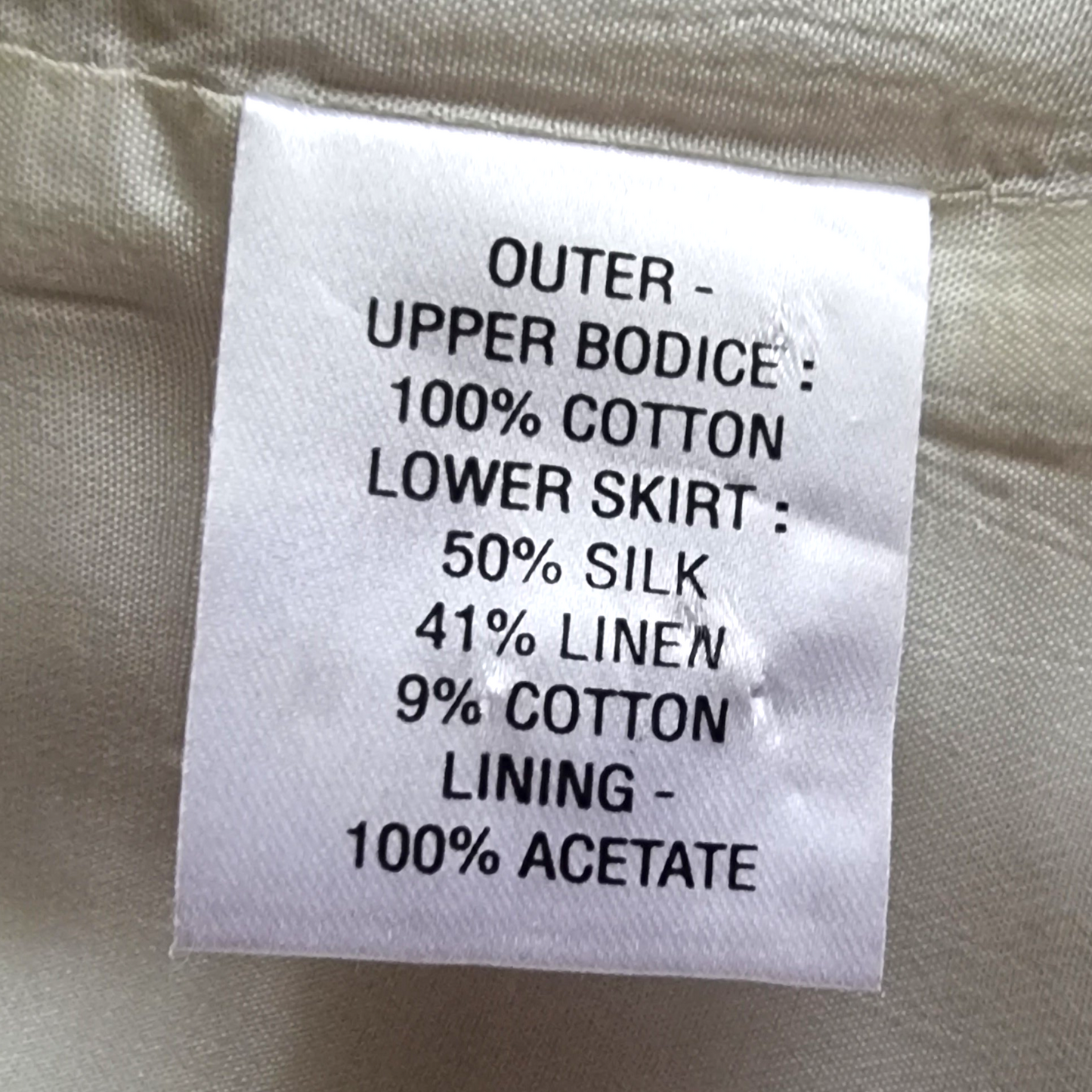 Dress label with fabric details on cream background