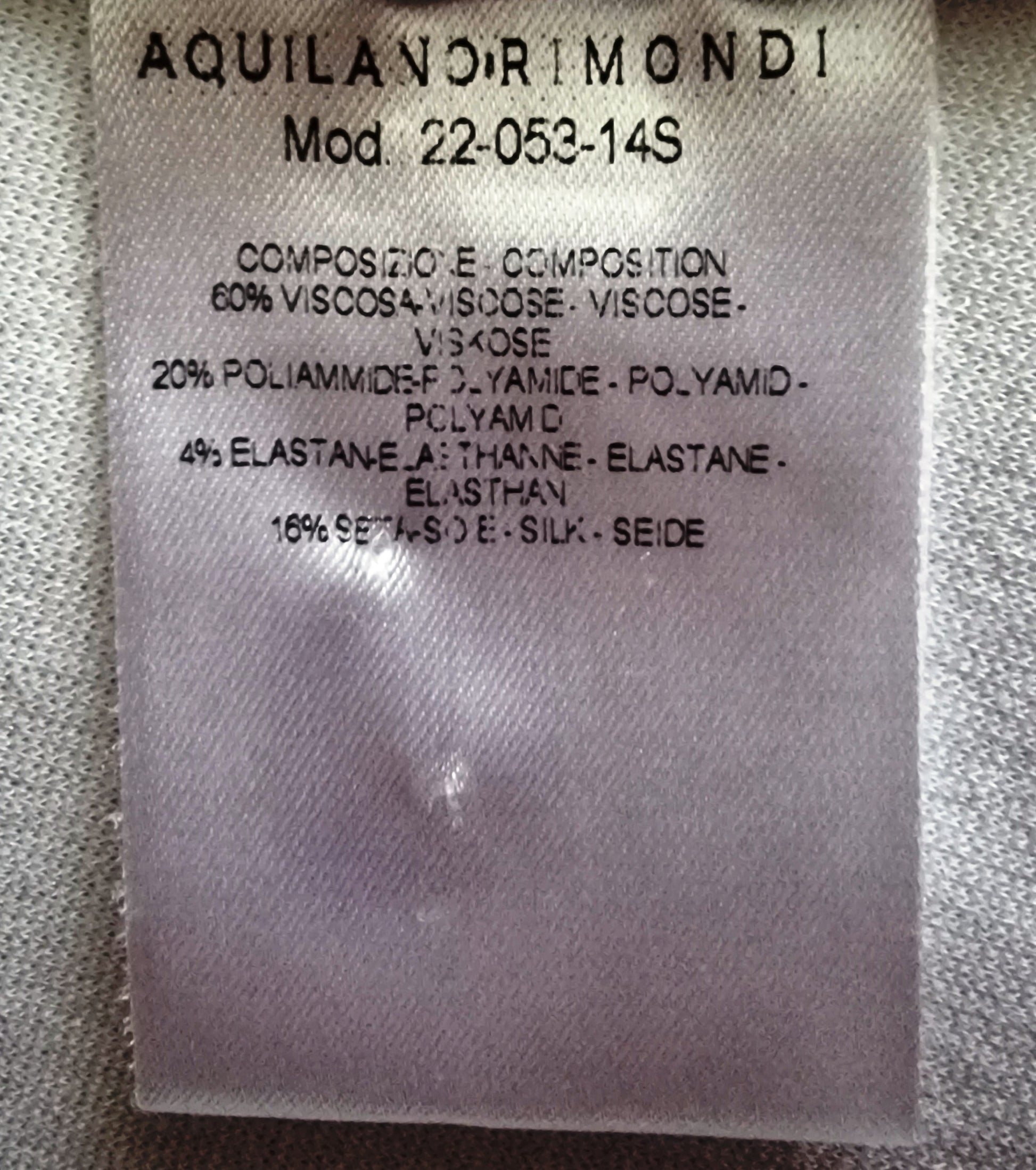 Fabric label with Aquilano Rimondi branding and material composition details on a textured fabric background.