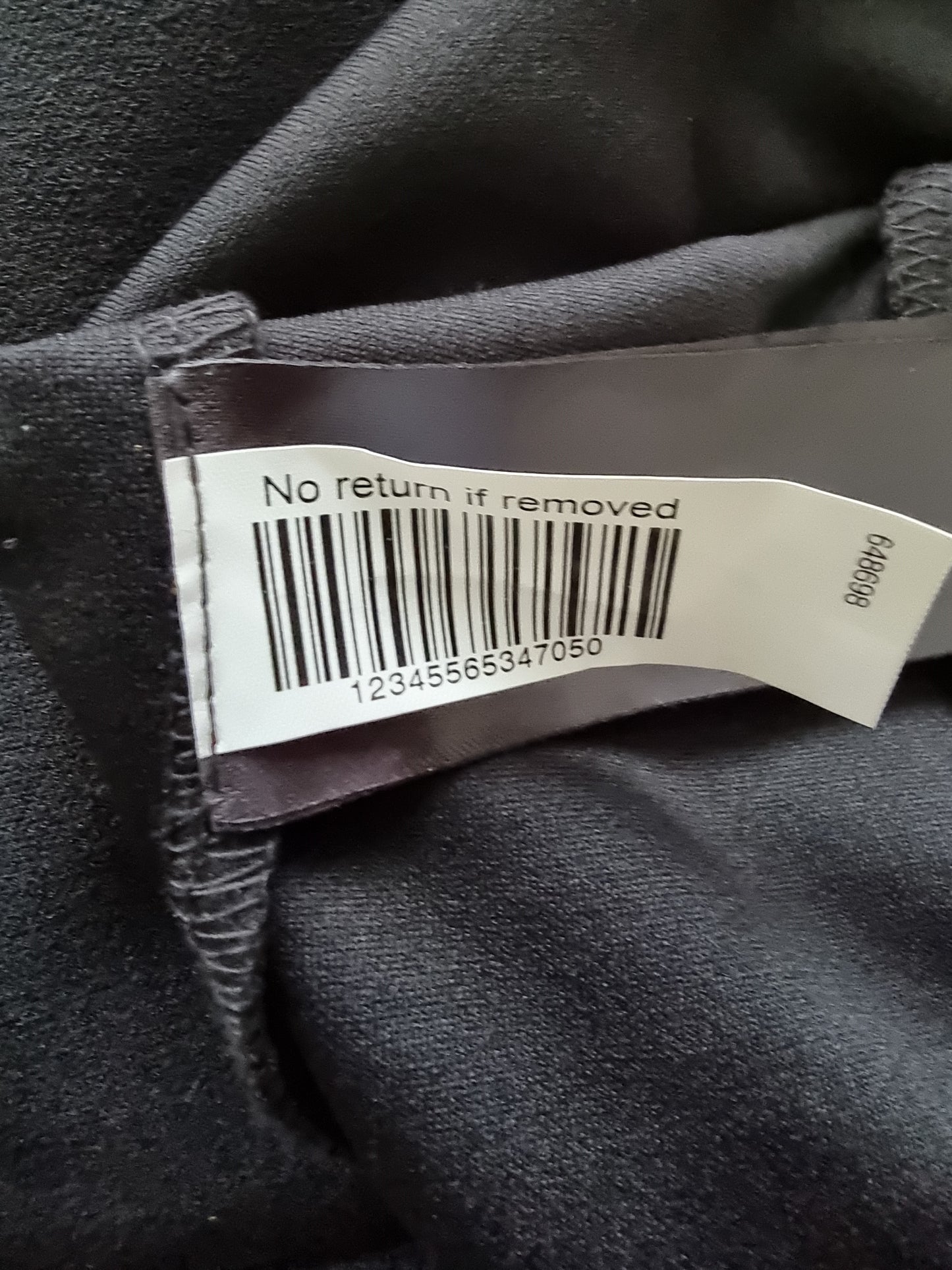 Clothing tag with a barcode on a dark fabric background