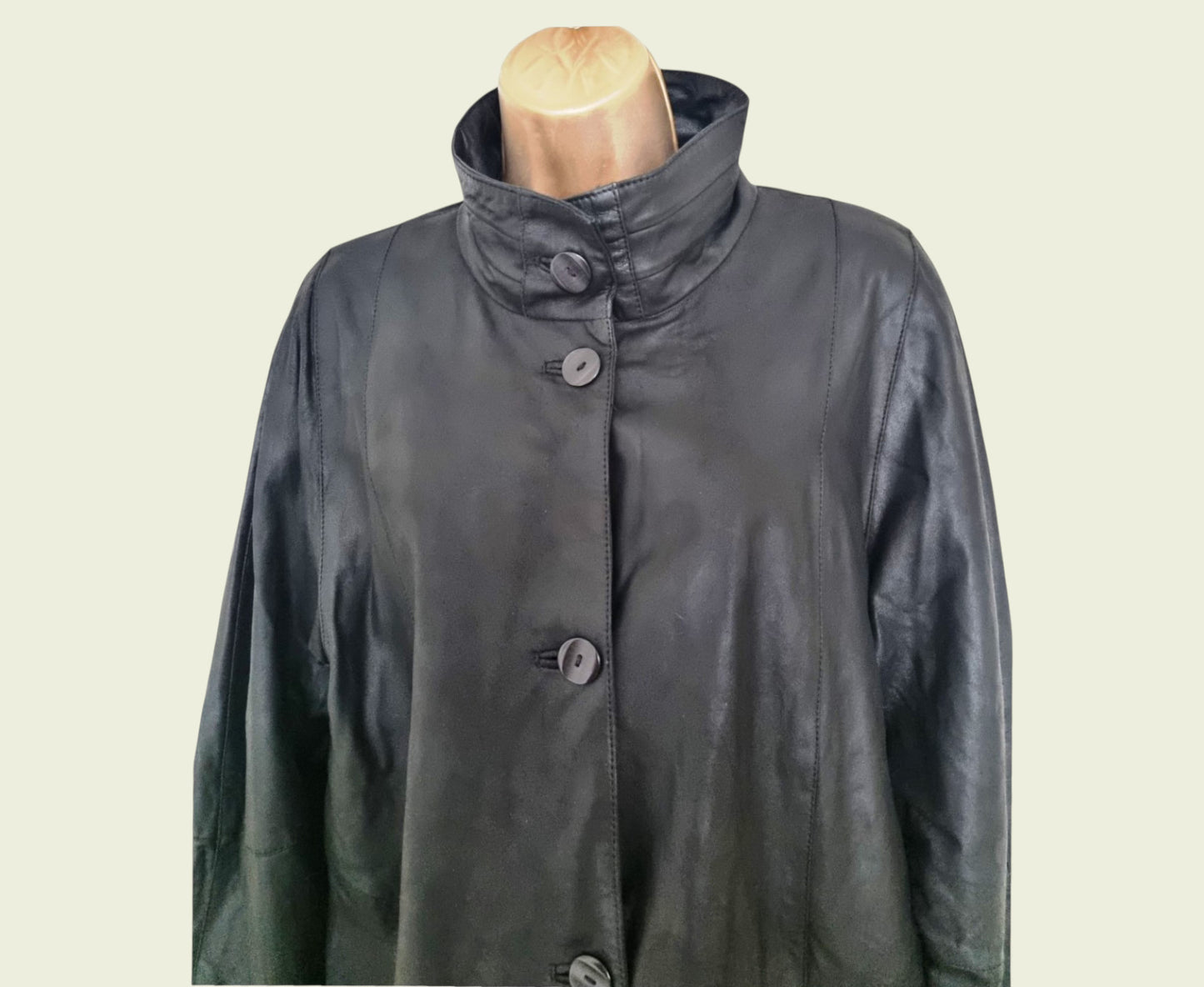 Black coat on a mannequin against a beige background