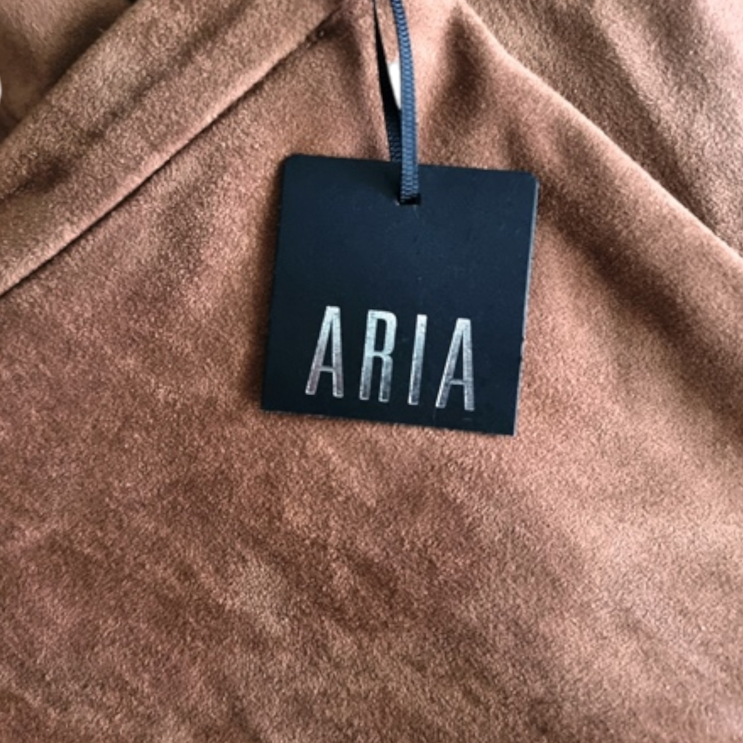 Brown fabric with a 'ARIA' tag hanging from it
