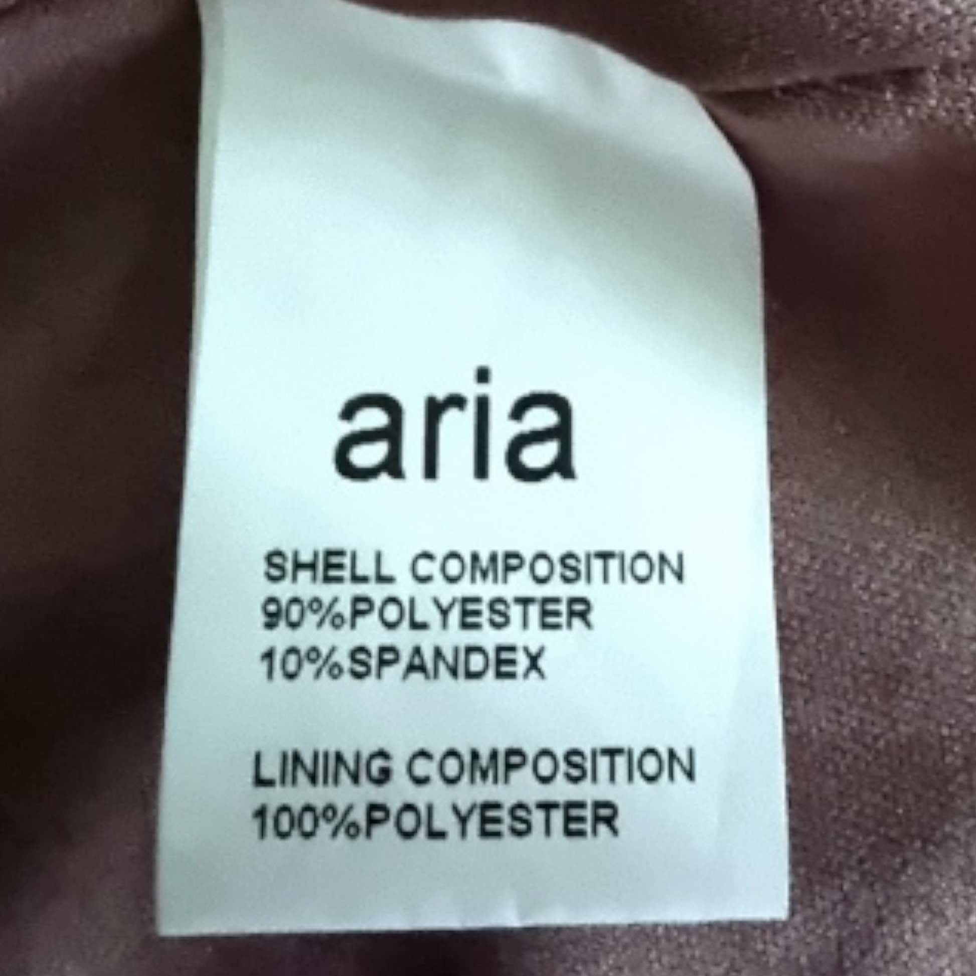 Aria label on a brownfabric with text about shell and lining compositions.