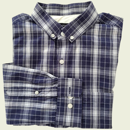 Folded blue and white plaid shirt on a beige background
