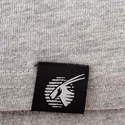 Black label with white logo on a gray fabric background