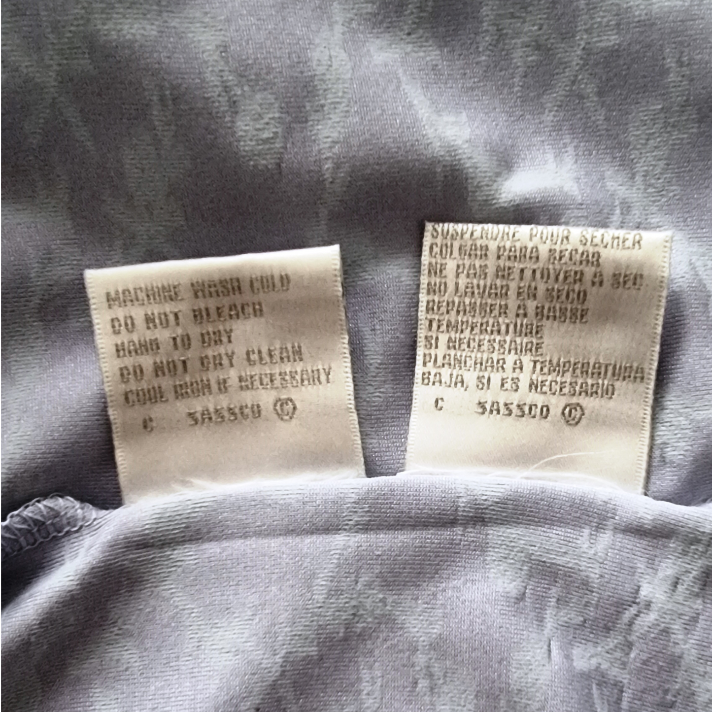 Two fabric labels on a gray fabric background