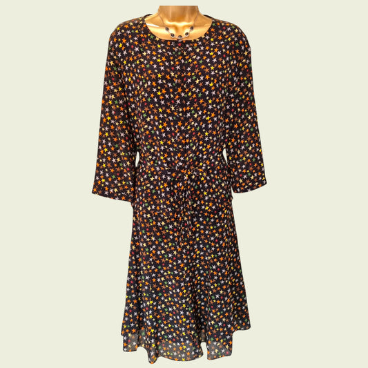 Mannequin wearing black blouse and skirt with star pattern on beige background