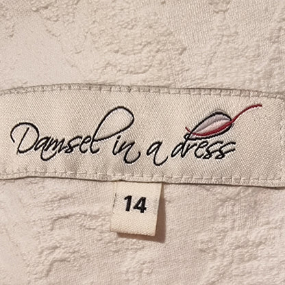 Label with 'Damsel in a Dress' branding on a textured fabric background