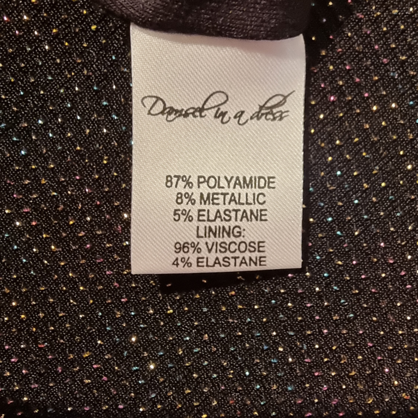 Clothing label with fabric composition details on a textured fabric background