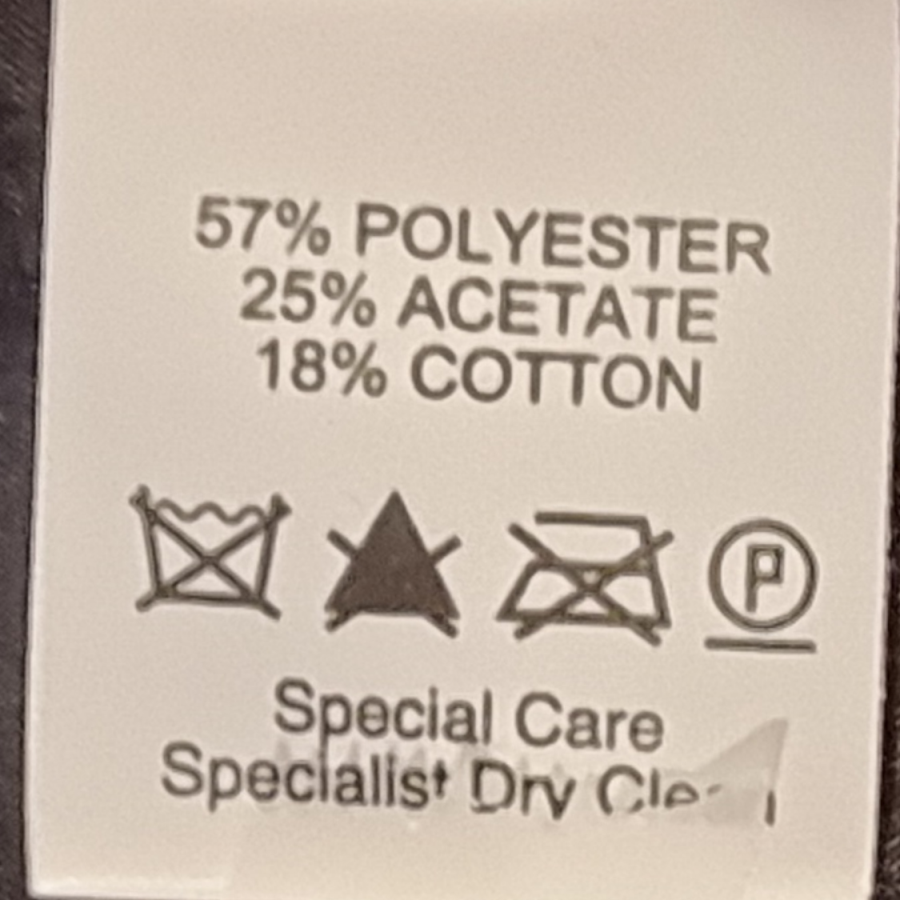 Fabric content label with percentages and care instructions on a beige background