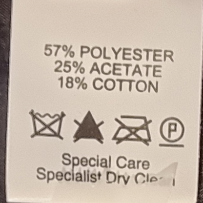 Fabric content label with percentages and care instructions on a beige background