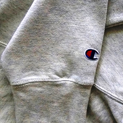Close-up of gray hoodie with a brand logo on the waistband.