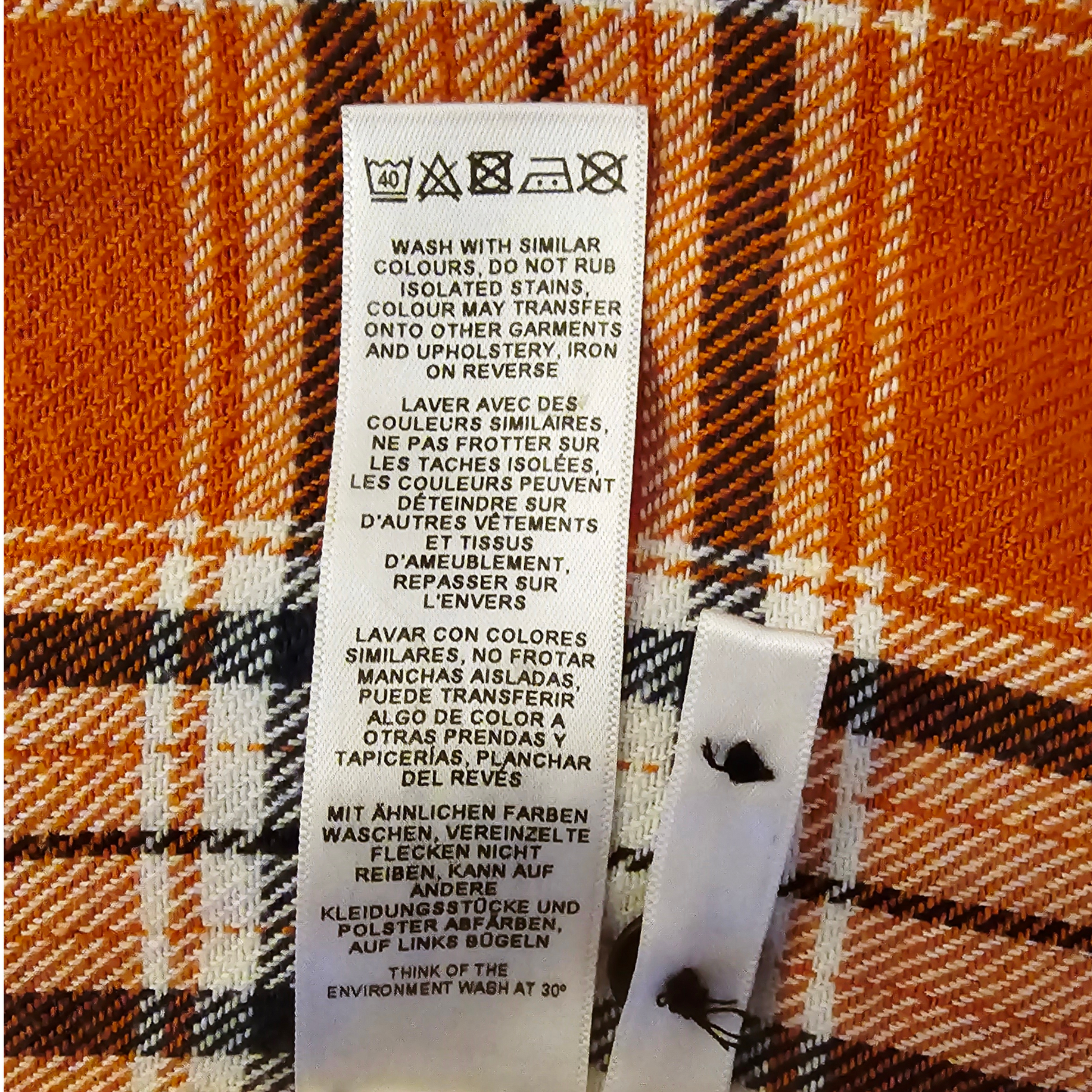 Fabric tag with care instructions on a plaid background