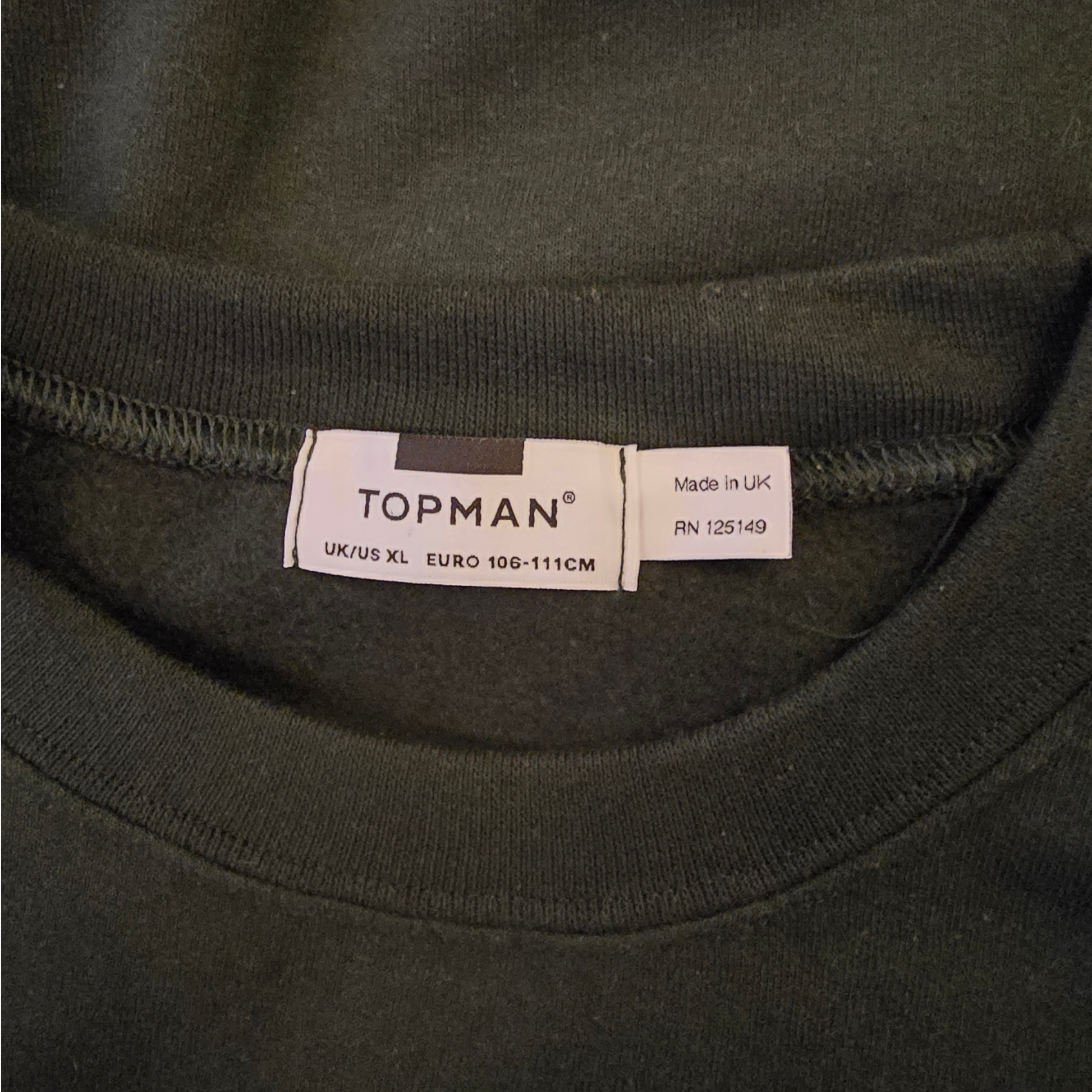 Topman label on a dark green garment