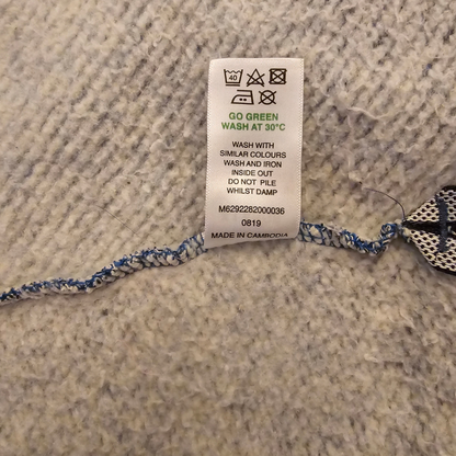 Fabric tag with washing instructions on a textured surface