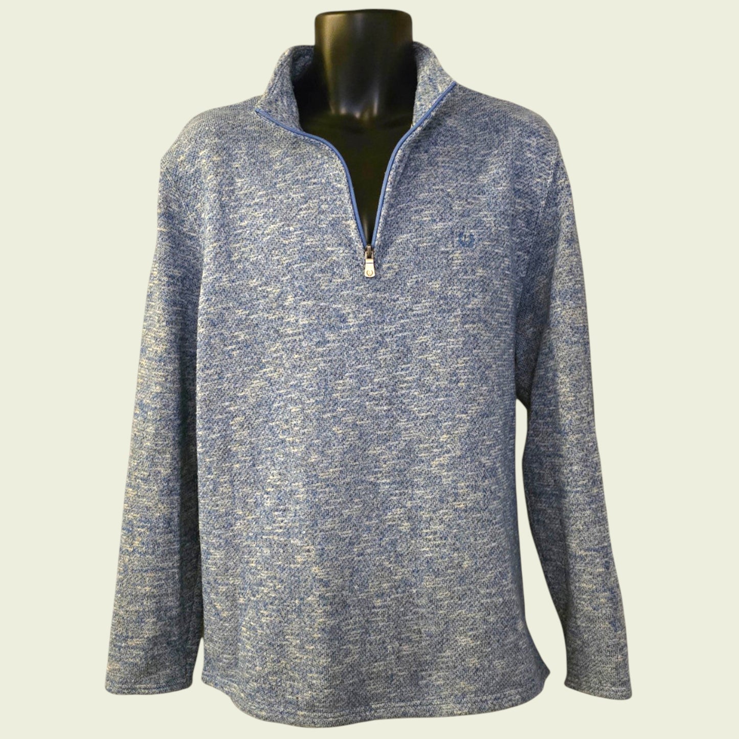 Blue knit sweater on a mannequin against a light background