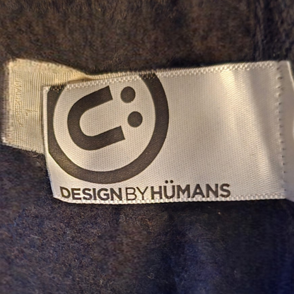 Label with 'Design by Humans' logo on a textured surface