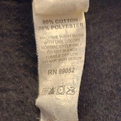 Fabric tag with washing instructions and material composition on a dark fabric background