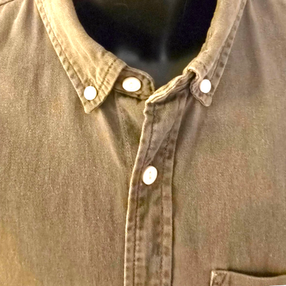 Close-up of a khaki denim shirt with white buttons