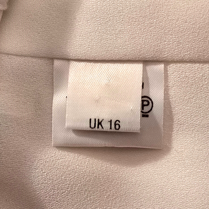 Clothing label with size 'UK 16' on a beige fabric background