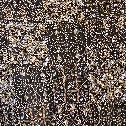 Decorative fabric with intricate patterns and embellishments on a black background