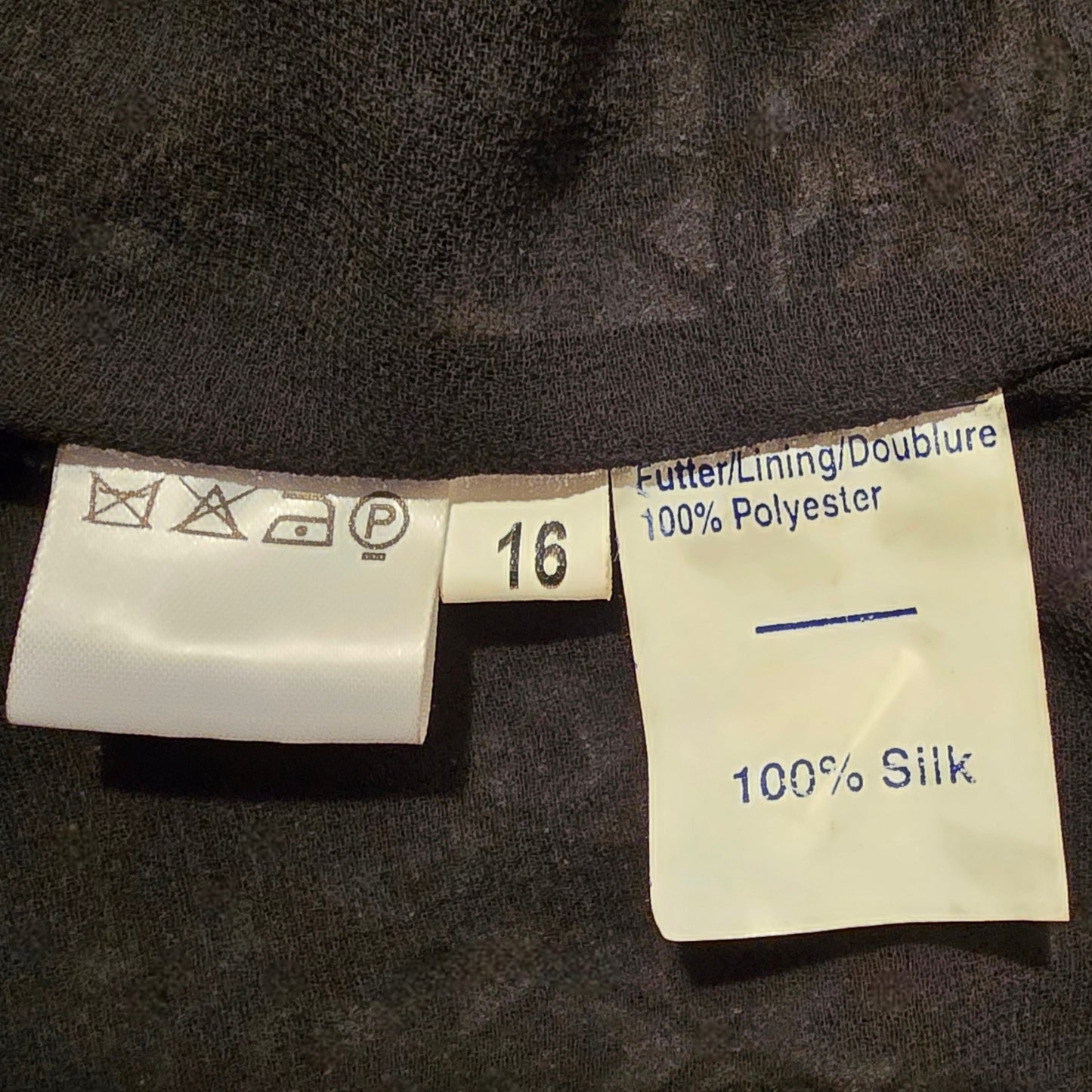 Clothing labels on a dark fabric background