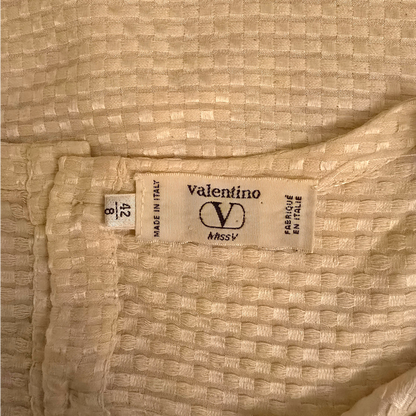 Valentino label on a textured beige fabric background