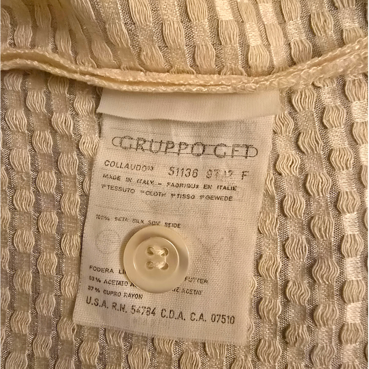 Close-up of a label on a textured beige fabric with a button.