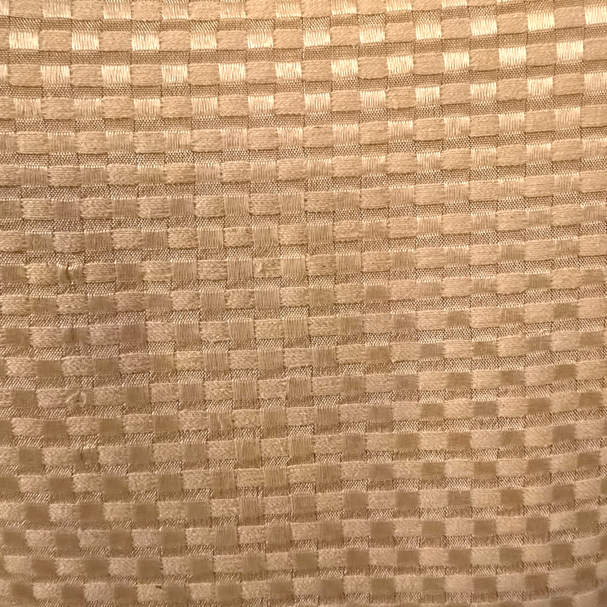 Close-up of a textured beige fabric with a checkered pattern