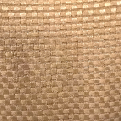 Close-up of a textured beige fabric with a checkered pattern