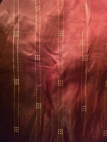 Close-up of maroon fabric with gold thread patterns