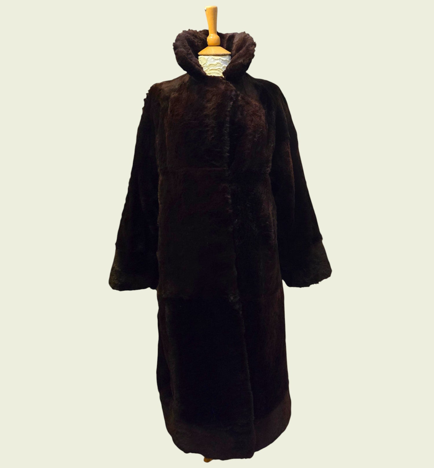Brown fur coat on a mannequin against a plain background