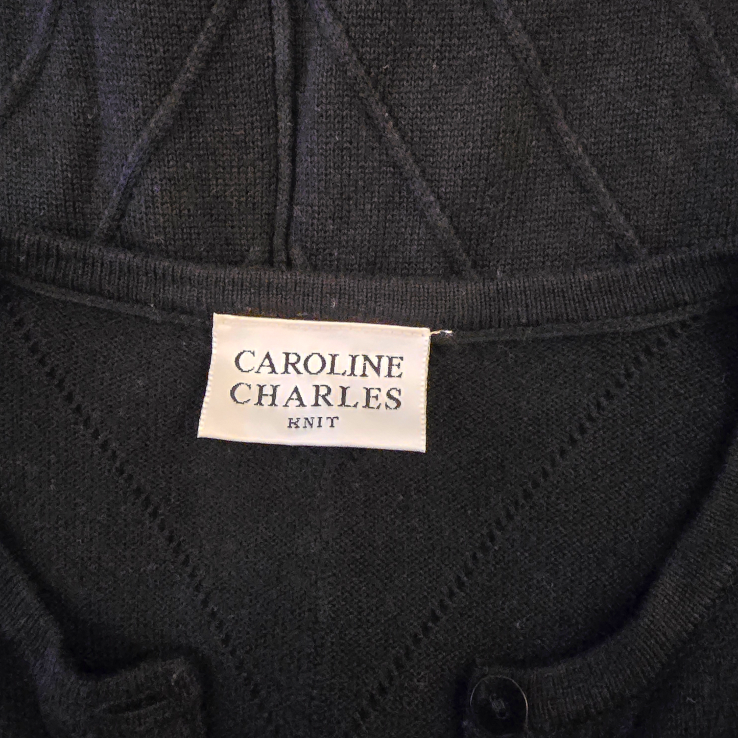 Black knit garment with 'Caroline Charles Knit' label
