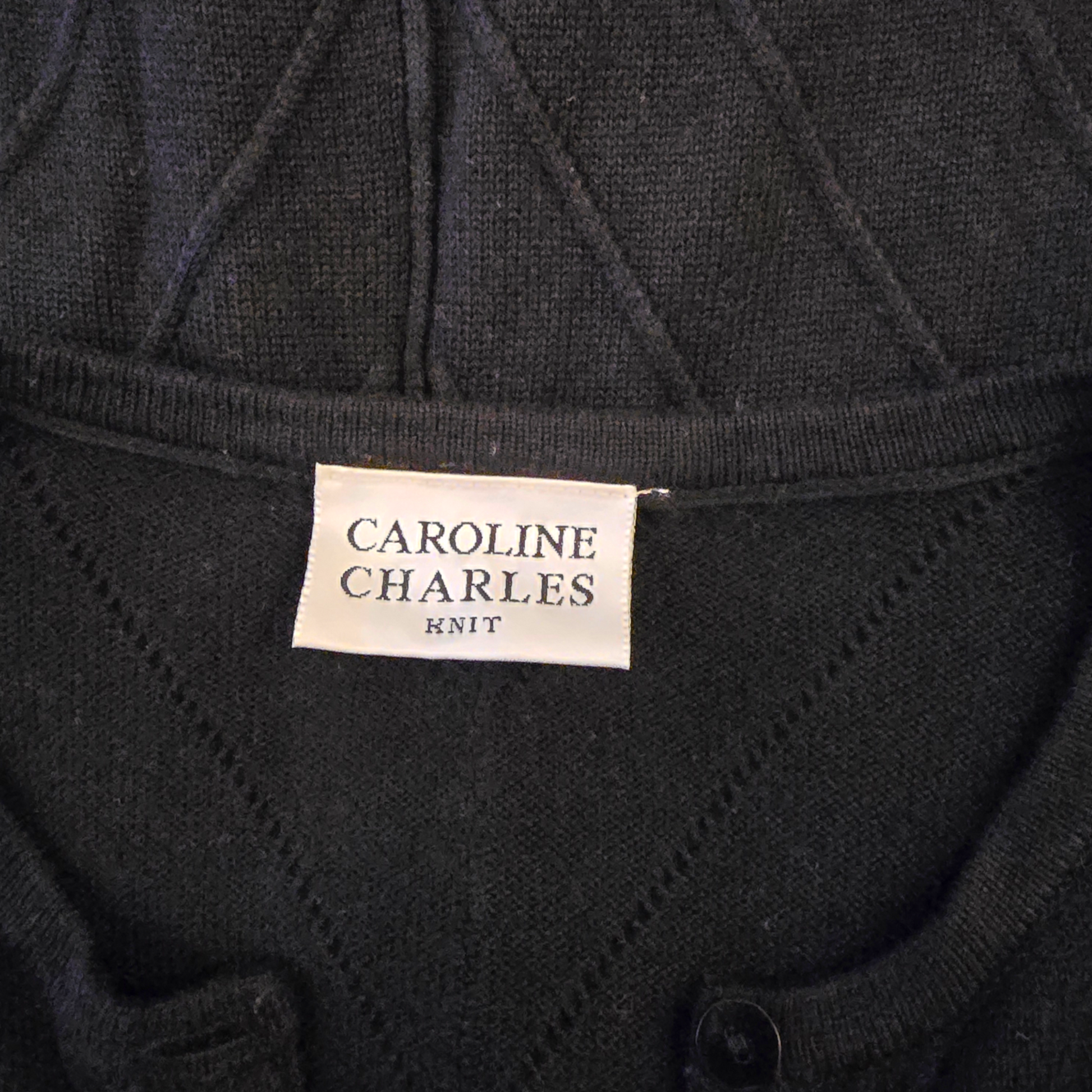 Black knit garment with 'Caroline Charles Knit' label