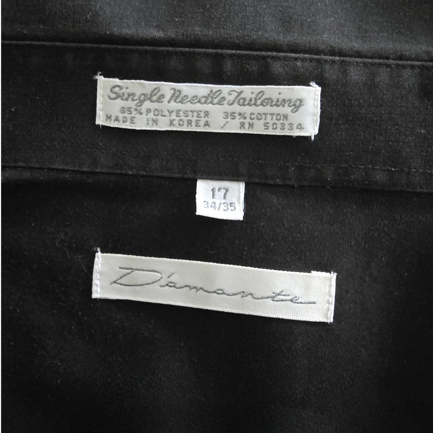 Black fabric with 'D'amante' label and size tag on a black background