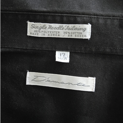Black fabric with 'D'amante' label and size tag on a black background