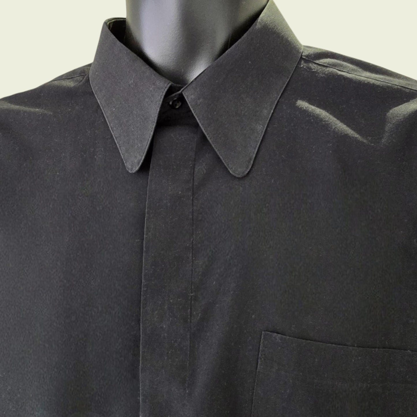 Black shirt on a mannequin with a plain background