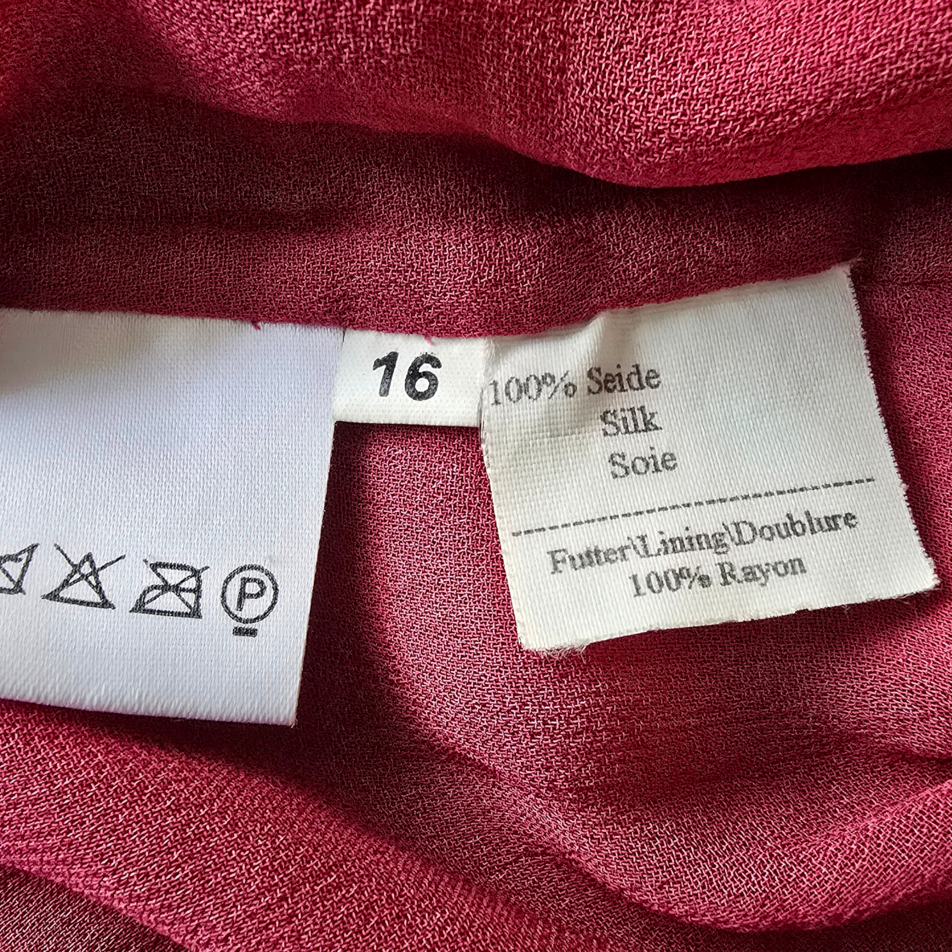 Close-up of fabric with labels indicating material composition on a red fabric background.