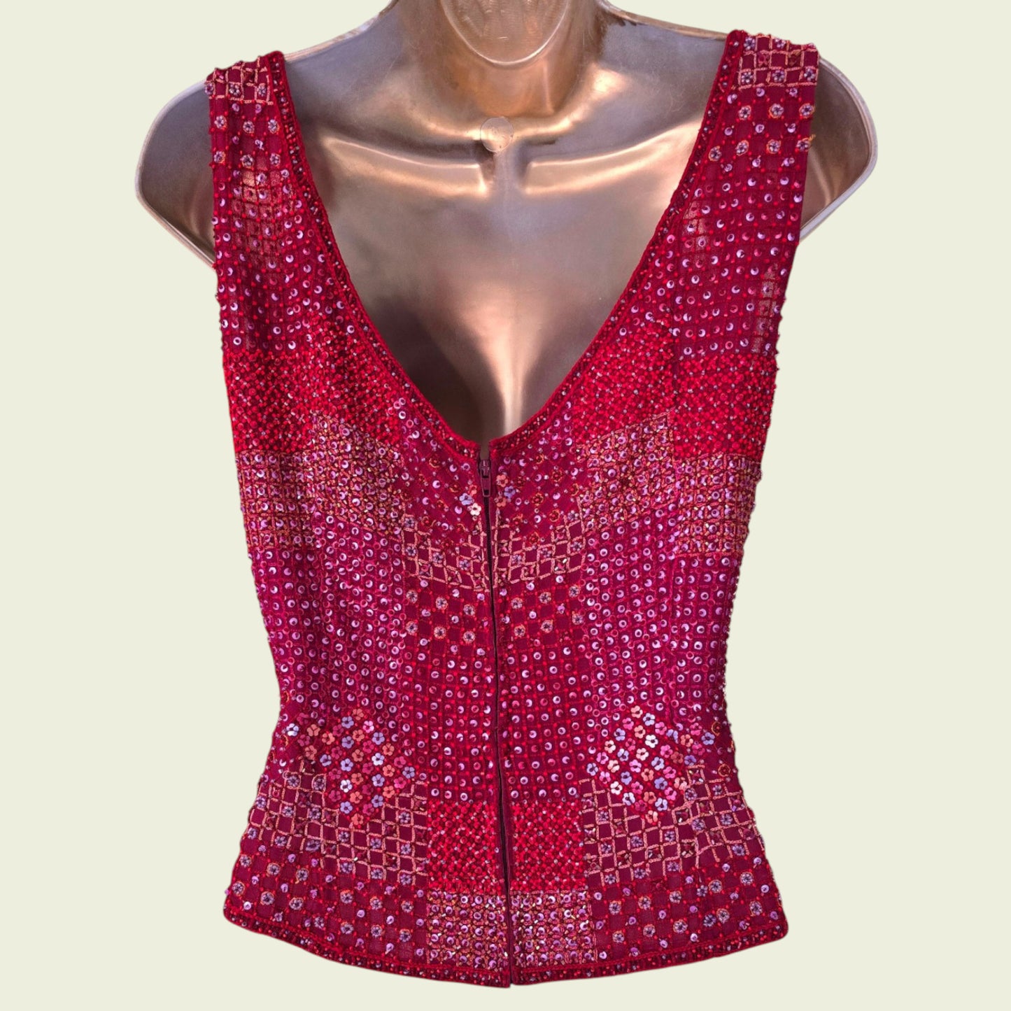 Red sequined top on a mannequin against a light beige background