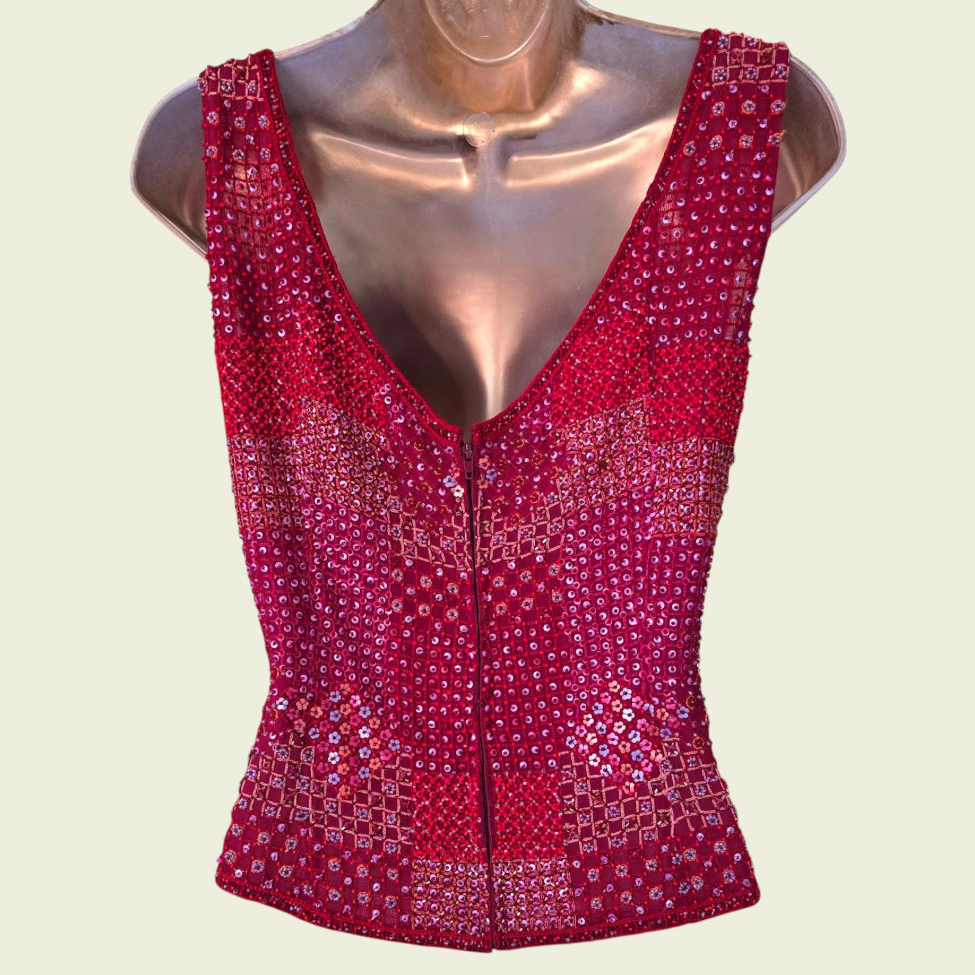 Red sequined top on a mannequin against a light beige background