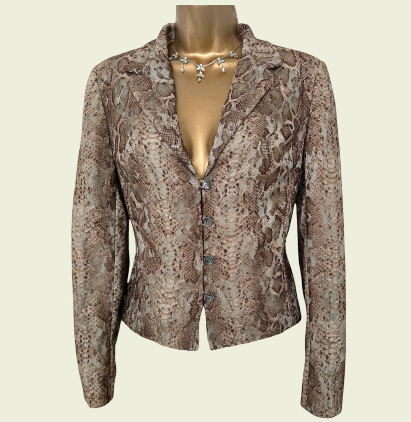 Snakeskin patterned jacket on a mannequin against a beige background
