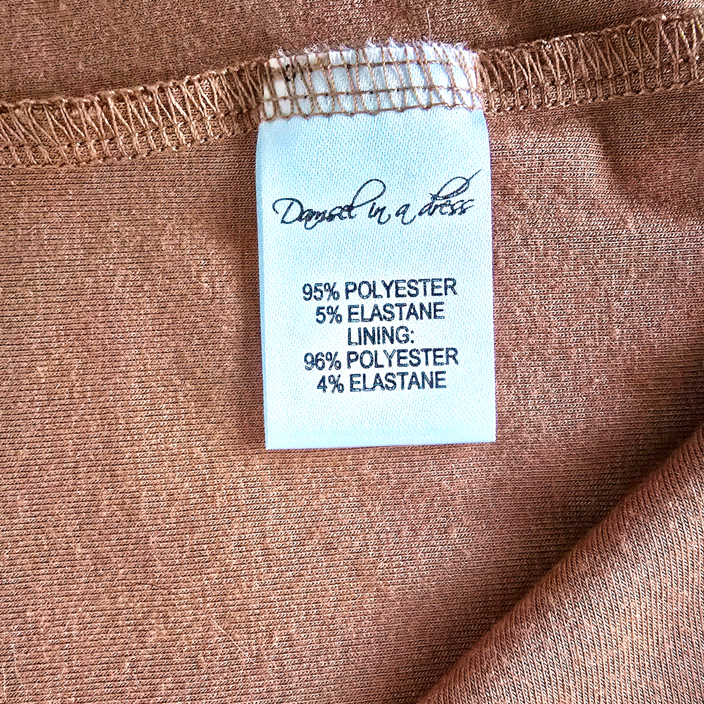 Fabric label with material information on a brown fabric background