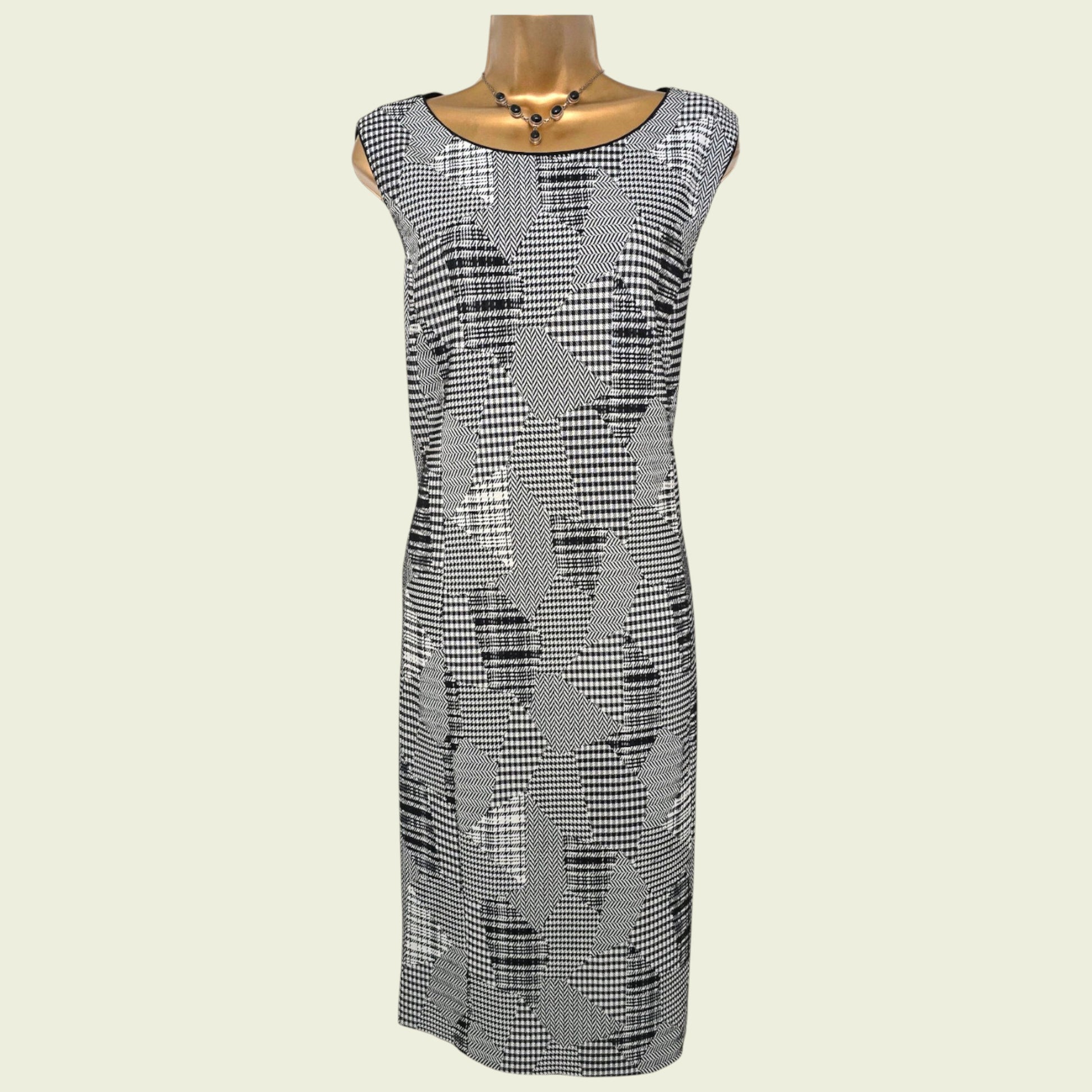Black and white patterned dress on a mannequin against a beige background