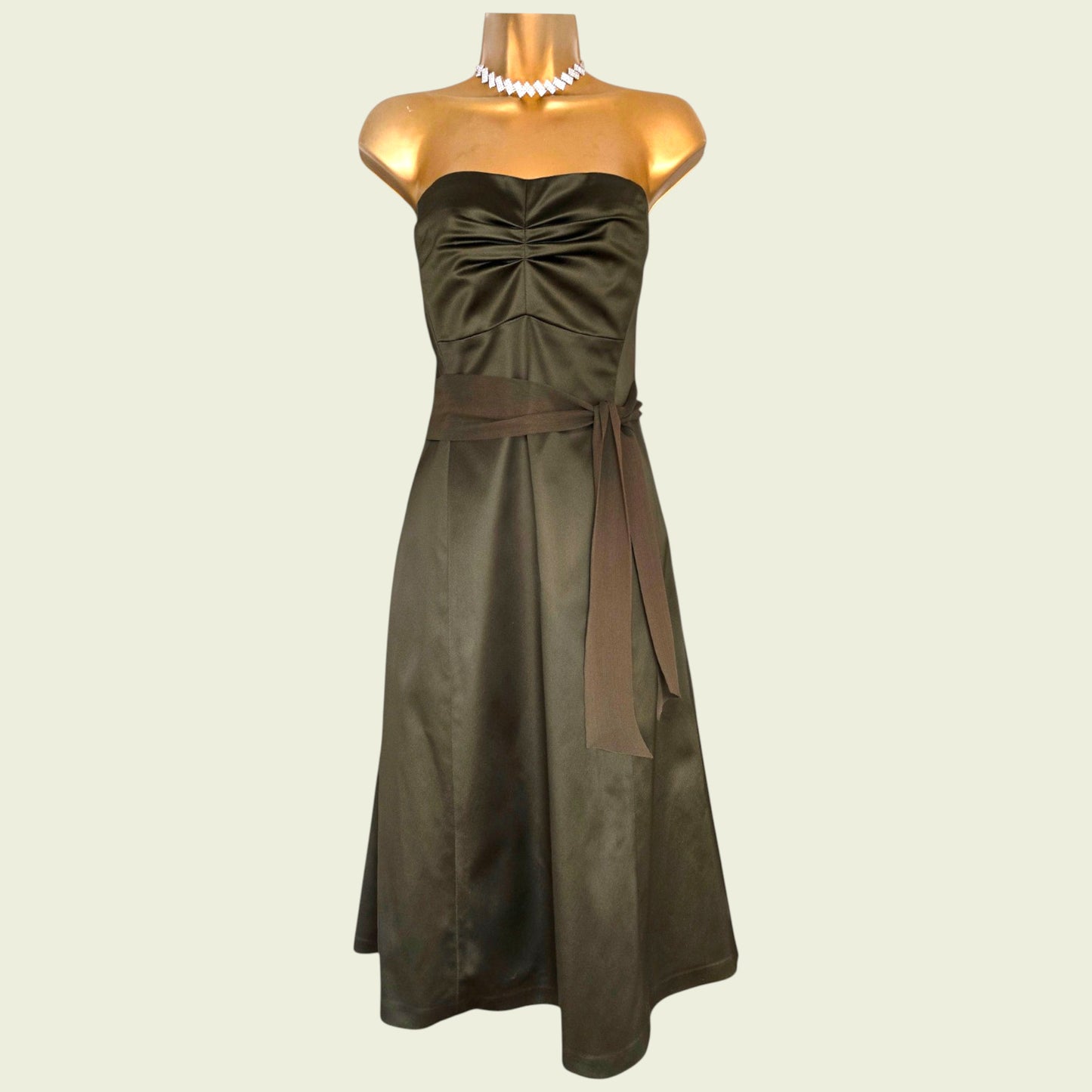 Mannequin wearing an olive green dress on beige background