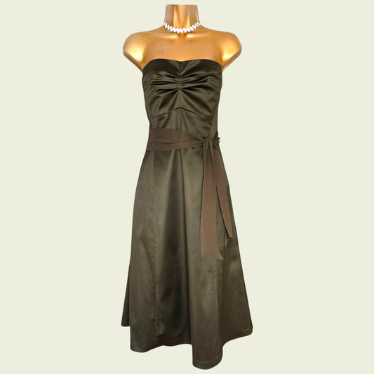 Mannequin wearing an olive green dress on beige background