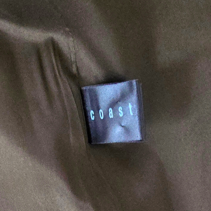 Garment label showing Coast on green background