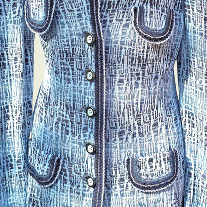 Jacket showing pocket detail of blue and white knitted jacket on a beige background