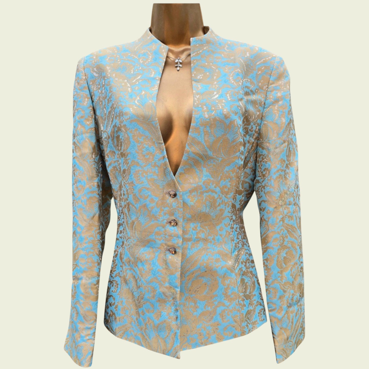 Mannequin wearing a light blue and gold jacket on a beige background